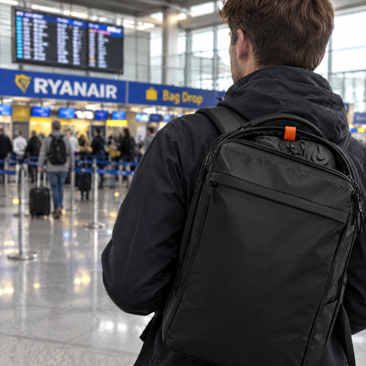 Traveller walking past the bag drop with a backpack packed with Solvi ClickVac