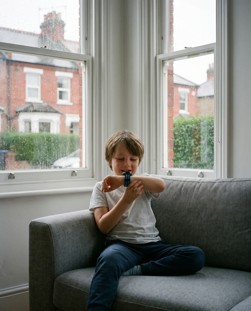 A child on a sofa talking into the watch as if calling a grandparent